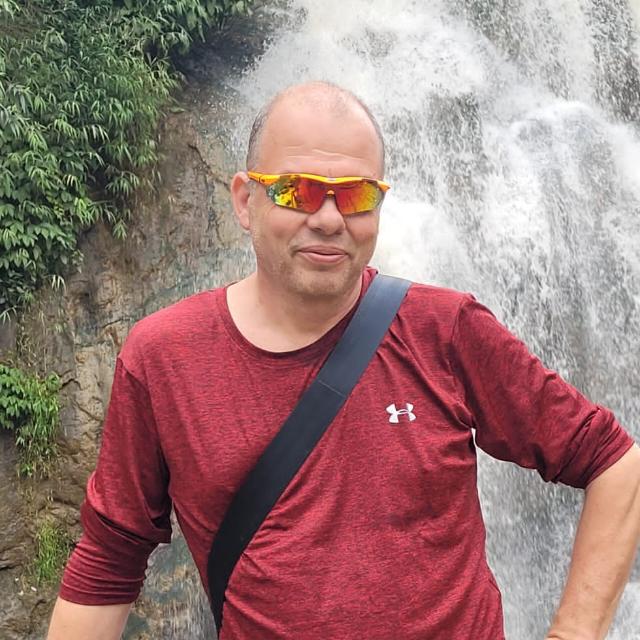 אודות/צרו קשר - גיורא נלקן, על רקע מפל מים