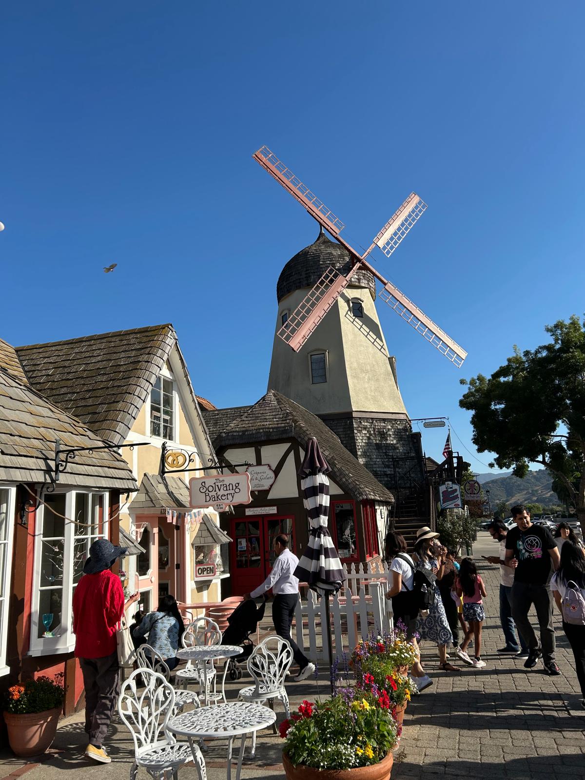 רחוב צבעוני בלב סולוונג, עיירה בסגנון דני עם בתי מאפה, תחנת רוח ומרפסות קטנות. רגע קסום שמרגיש כאילו קפצנו לאירופה בתוך טיול לארצות הברית.