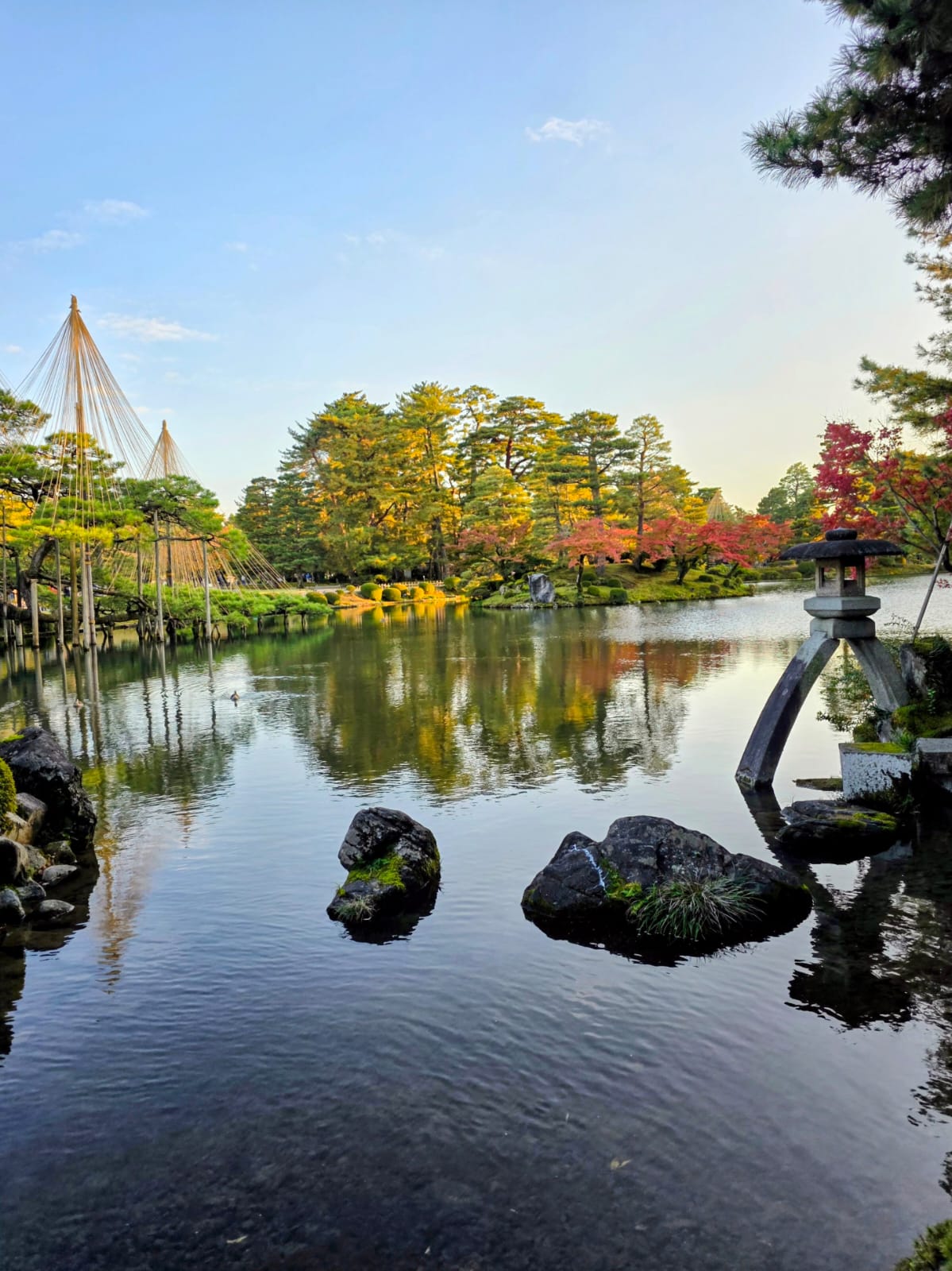 אגם קנרוקואן עם עצי שלכת ופנס אבן מסורתי במהלך טיול לקנאזווה יפן